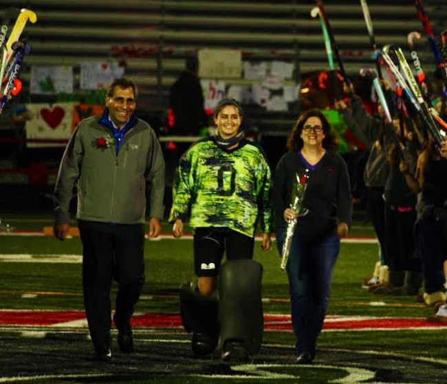 GREATEST SHOW ON TURF: After four years on the team and two years on varsity, Cohen is celebrated by her teammates alongside her parents as they participate in the senior night tradition during their last home game. The event culminated in the final win that Cohen would achieve as a member of DHS field hockey. 