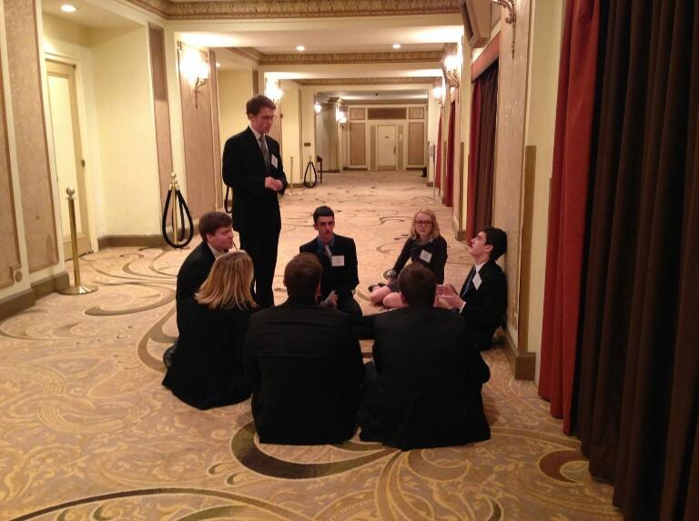 Model+UN+delegates%2C+dressed+for+success%2C+take+a+moment+to+rest+in+a+hallway.